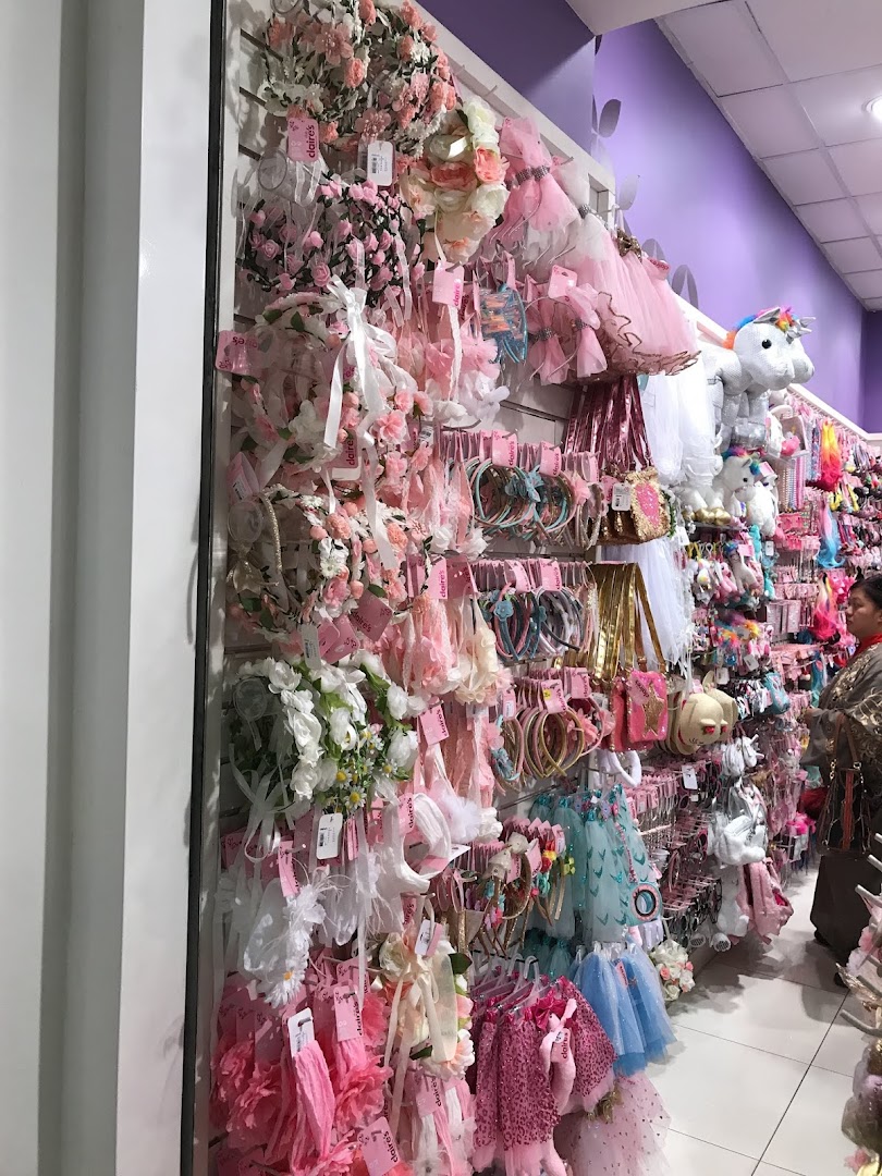 A wide selection of colorful hair accessories and party wear for girls displayed on shelves.