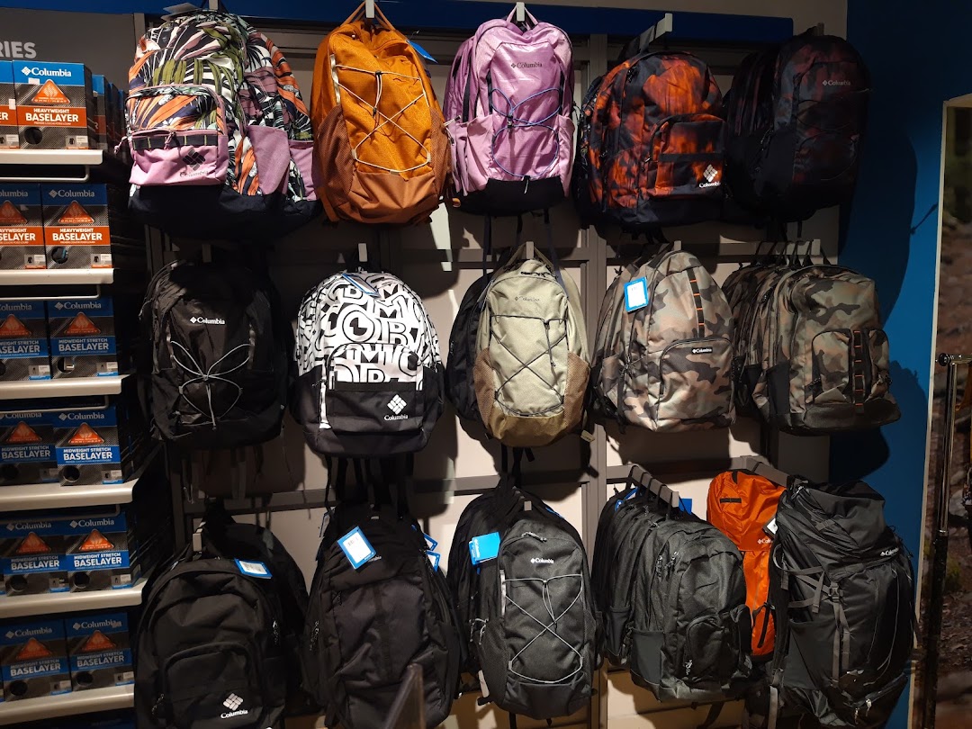 A wall display of various Columbia backpacks in different colors and patterns.