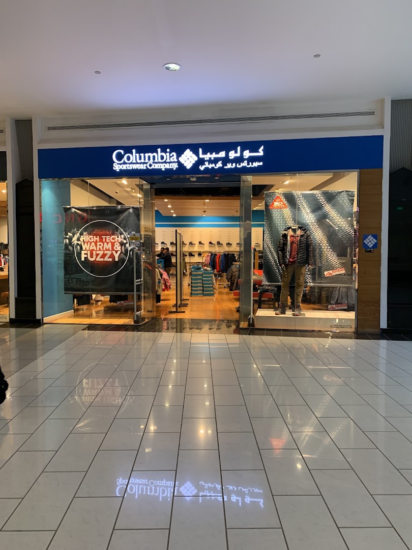 The exterior of a Columbia Sportswear Company store with mannequins and merchandise displayed.