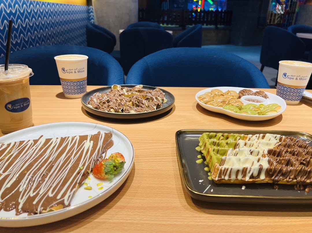 A table laden with delicious crepes, waffles, and coffee from Crepe and More.