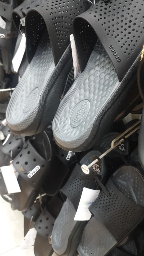 A close-up view of black Crocs sandals with LiteRide technology displayed on a rack.