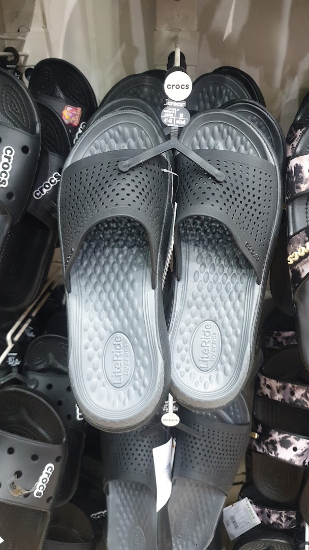 A display of various black Crocs sandals and slides, some with perforated uppers.