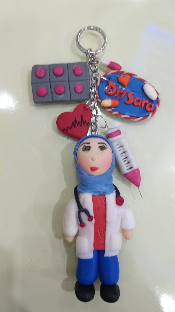 A handmade keychain featuring a doctor figurine with medical symbols and personalized text.