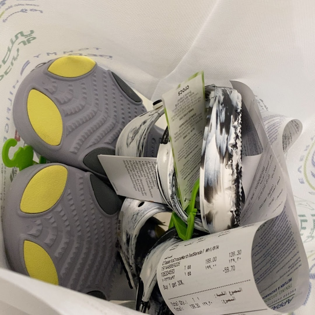 A close-up view of Crocs shoes and receipts inside a shopping bag.