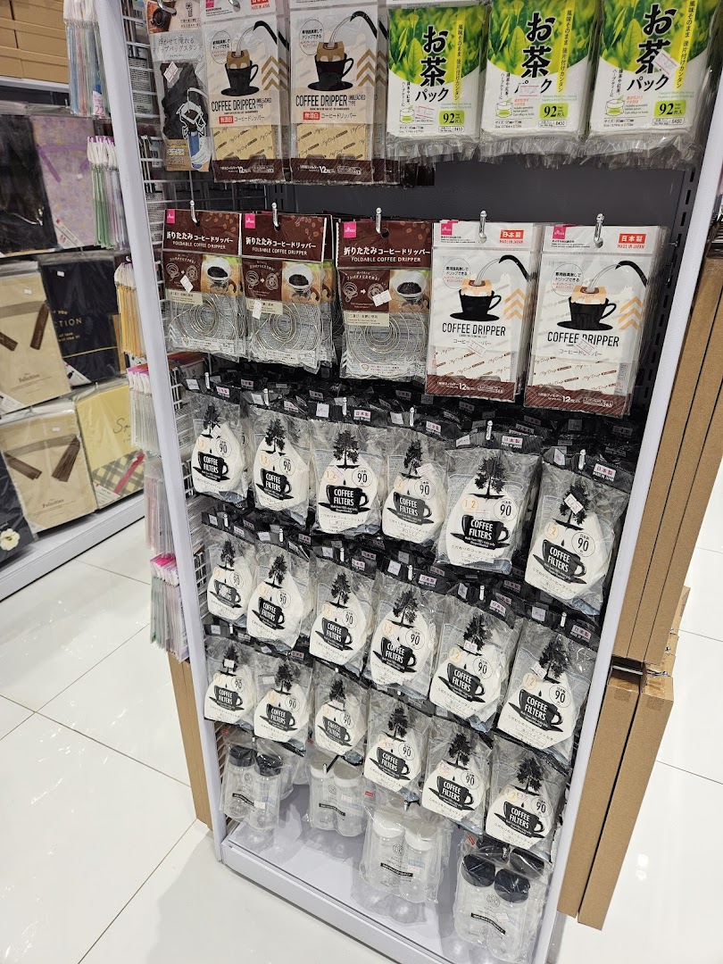 A display of coffee drippers and filters, along with tea packs and other household items at Daiso Japan.