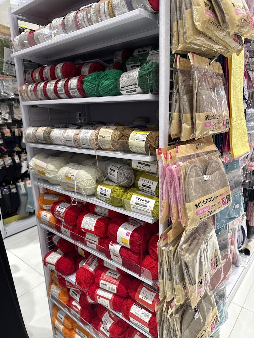 Shelves stocked with colorful yarn and packaged slippers at Daiso Japan.