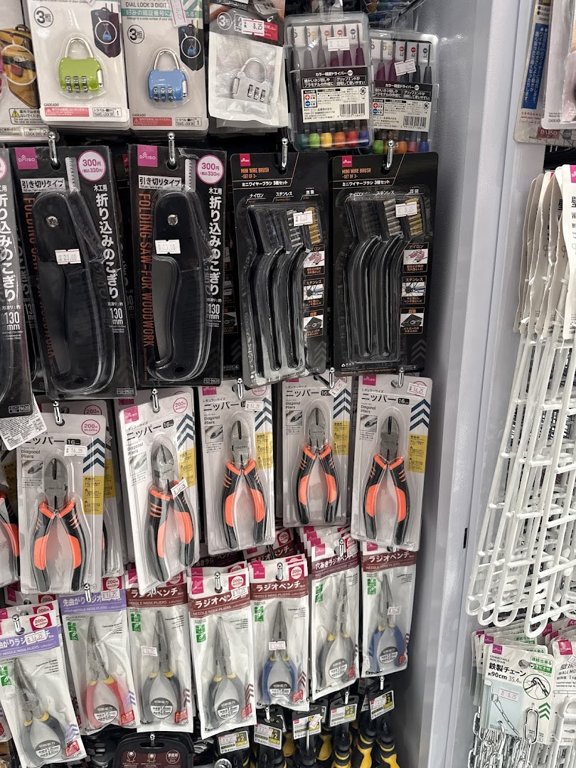 A display of various tools and hardware items, including pliers, saws, and brushes, neatly packaged and organized.