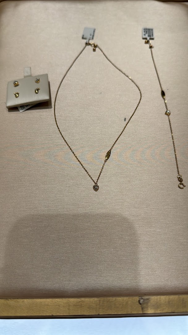A display of delicate gold necklaces and earrings with diamond accents.