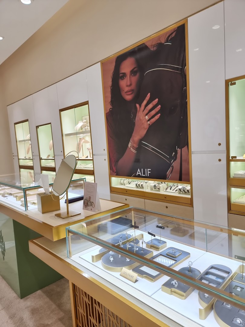 Interior view of a Damas Jewellery store showcasing elegant displays of jewelry and a large advertisement.