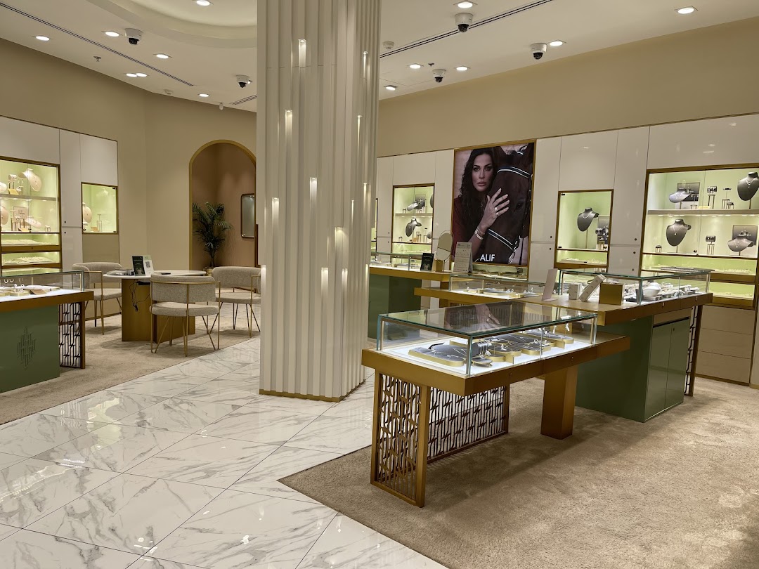 Interior view of a luxurious jewelry store with display cases and a large advertisement.