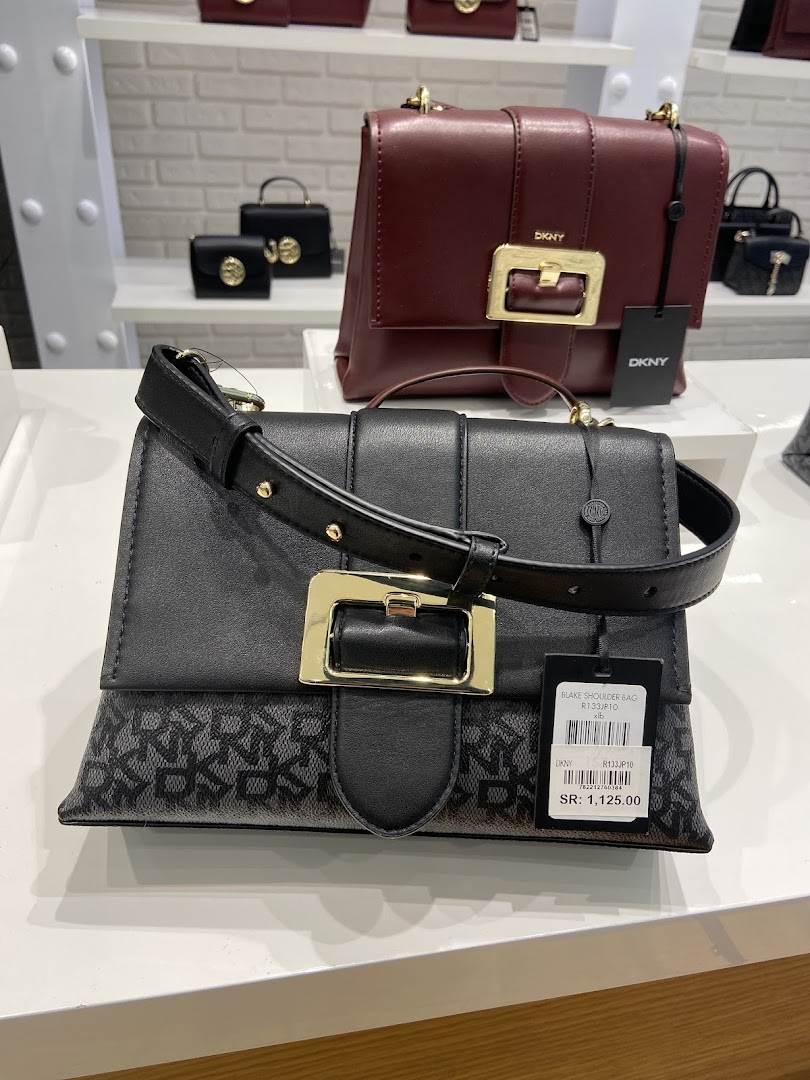 DKNY shop interior displaying various handbags on shelves, with a focus on two prominent styles.
