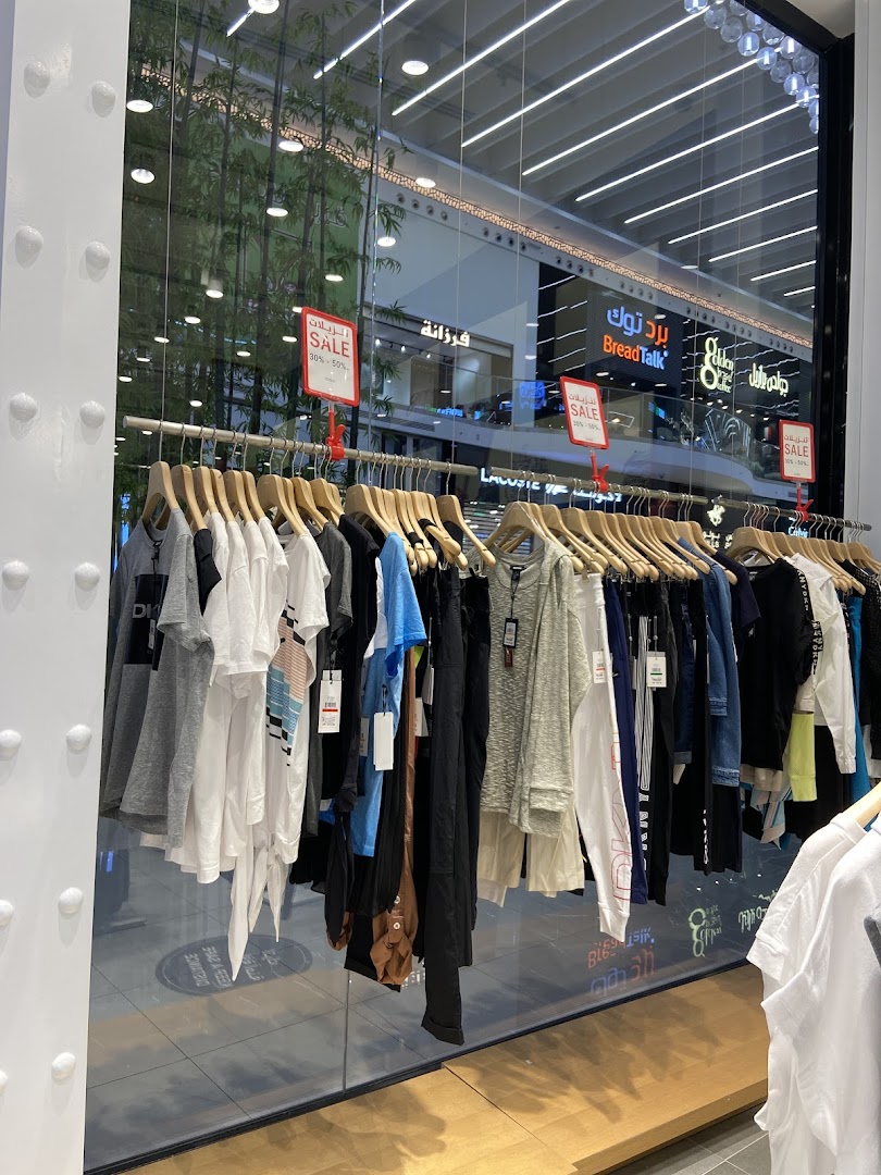 DKNY shop window displaying a rack of sale clothing with sale signs.