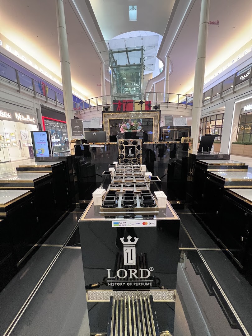 A luxurious perfume display stand with multiple bottles in a shopping mall.