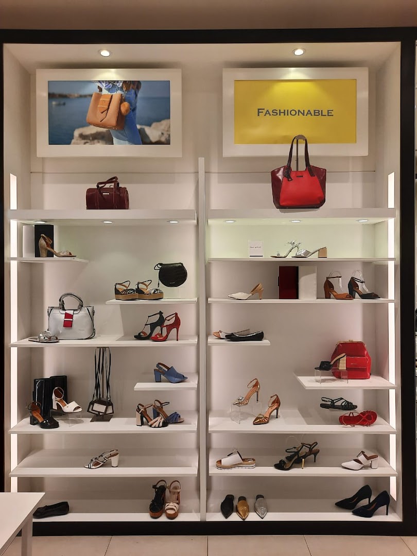 A well-lit display shelf showcasing a variety of fashionable women's shoes and handbags.
