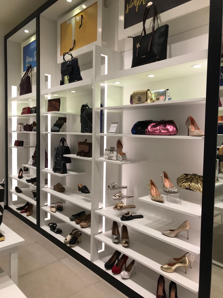 A well-lit retail display showcasing a variety of stylish handbags and shoes.