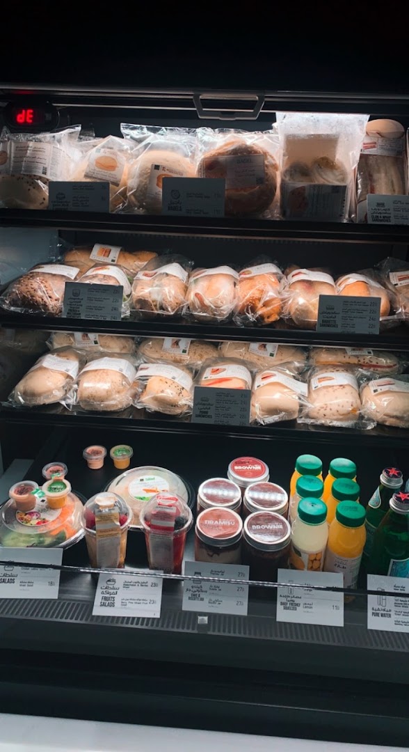 A refrigerated display case filled with various pre-packaged sandwiches, salads, desserts, and beverages.