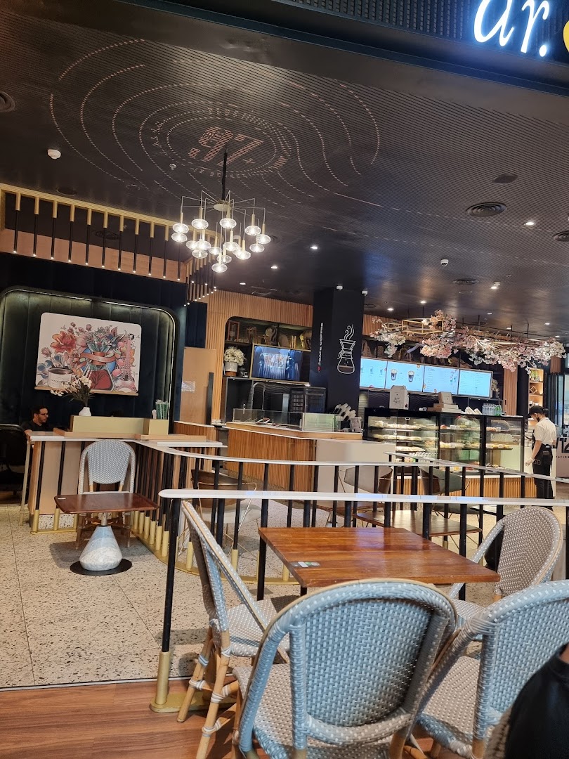 Interior view of a modern coffee shop with seating and a counter.