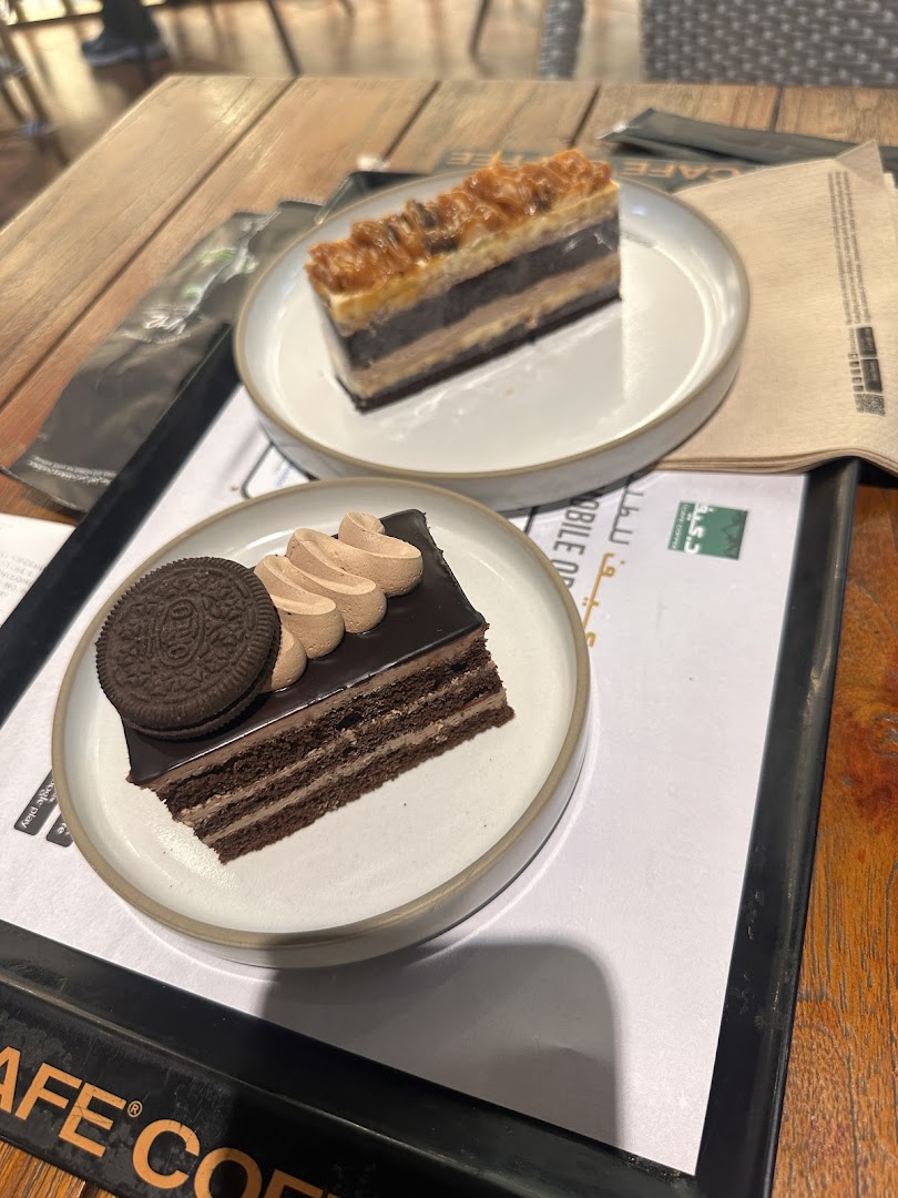Two slices of cake, one chocolate with an Oreo, and another layered cake with caramel.