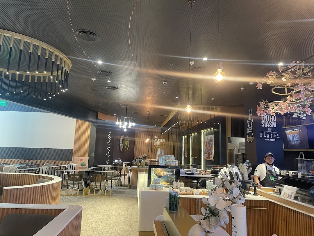 Interior view of a modern coffee shop with stylish seating, a barista counter, and decorative lighting.