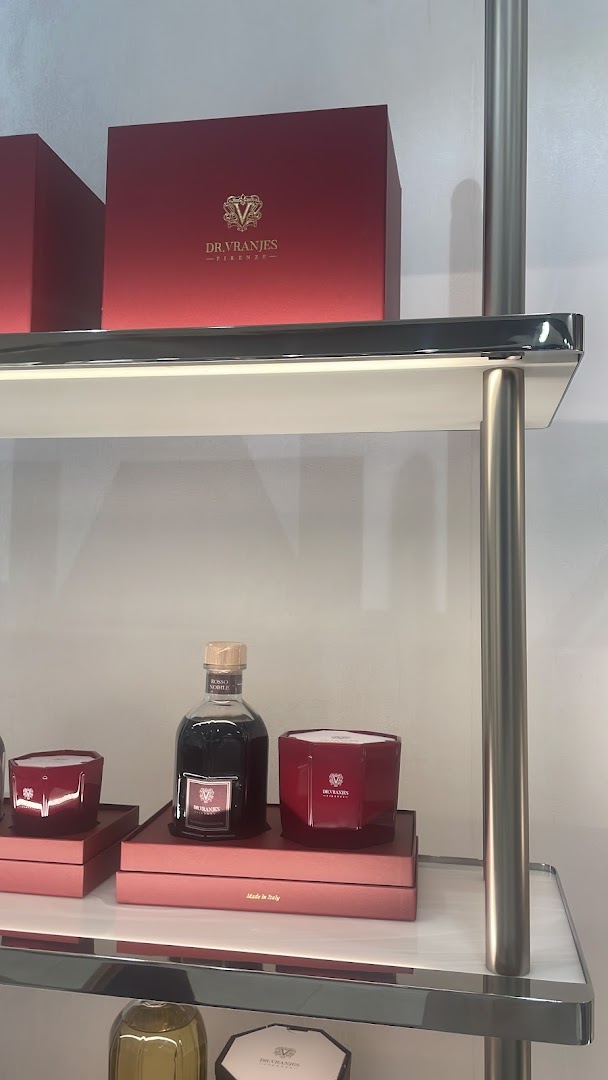 Dr. Vranjes Firenze products displayed on shelves, including red gift boxes and a bottle of fragrance.
