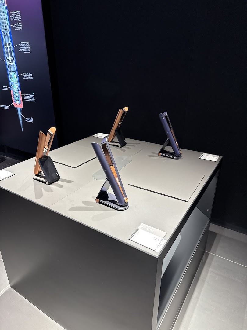 Dyson hair straighteners displayed on a modern retail counter with informational graphics.