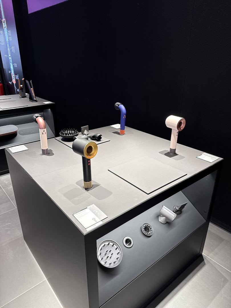 Dyson hair dryers and accessories displayed on a modern retail counter.