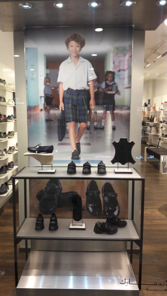 ECCO shoe store window display featuring children's school shoes and a promotional image.