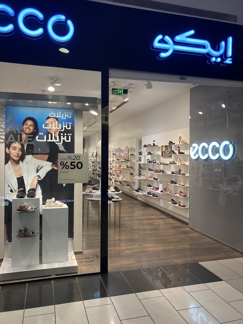 The entrance of an ECCO shoe store, showcasing a sale with shoes displayed in the window and on shelves inside.