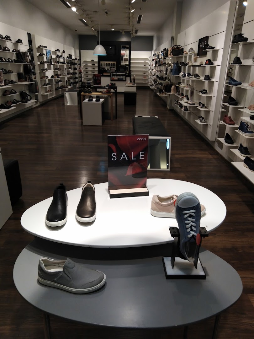 Interior view of an ECCO shoe store showcasing a variety of footwear on display, with a prominent sale sign.