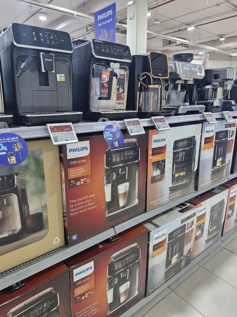 A display of various Philips coffee machines and their packaging on shelves.