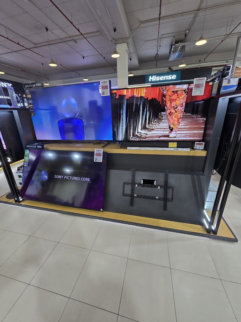 Display of various large televisions, including Sony and Hisense brands, in a retail store.