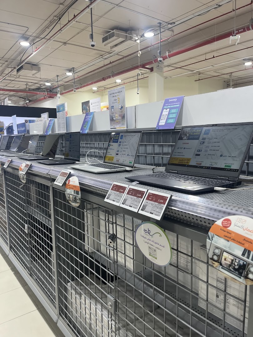 A display of various laptops for sale at eXtra, with price tags and promotional materials.
