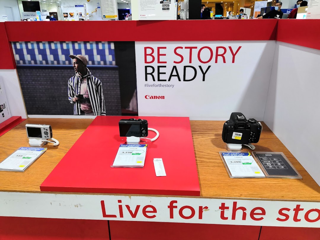 Display of Canon cameras and accessories with promotional text and pricing.