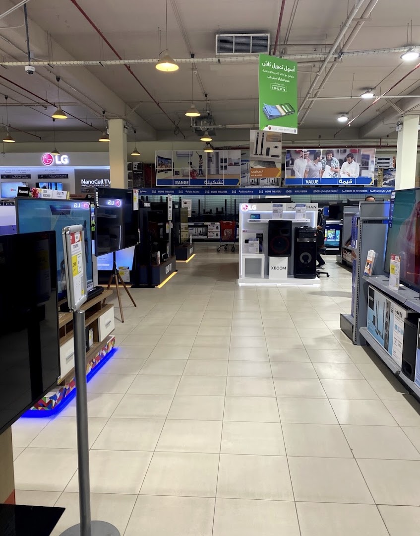 Interior view of an electronics store showcasing TVs, audio equipment, and various brands.