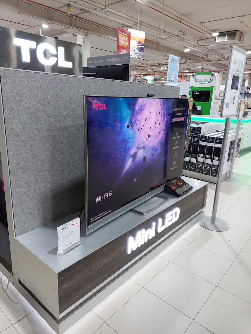 A TCL Mini LED television is displayed with its features highlighted, in a retail store setting.