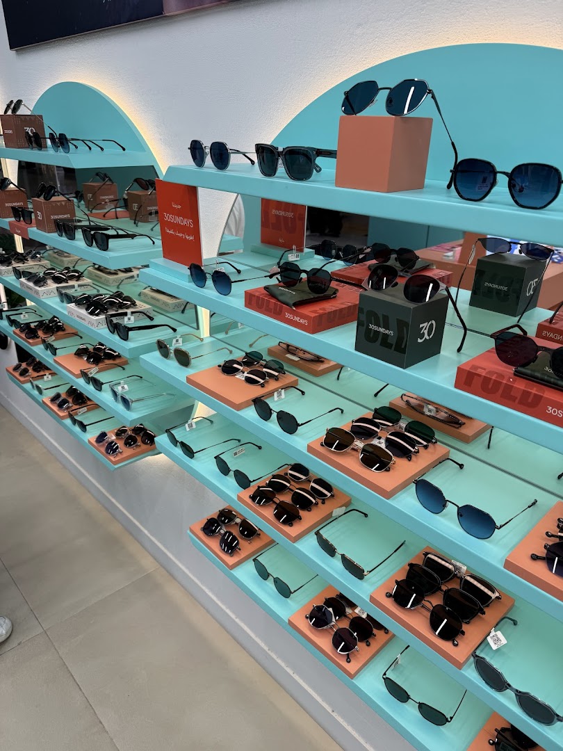 A wide selection of stylish sunglasses displayed on shelves in a modern retail store.