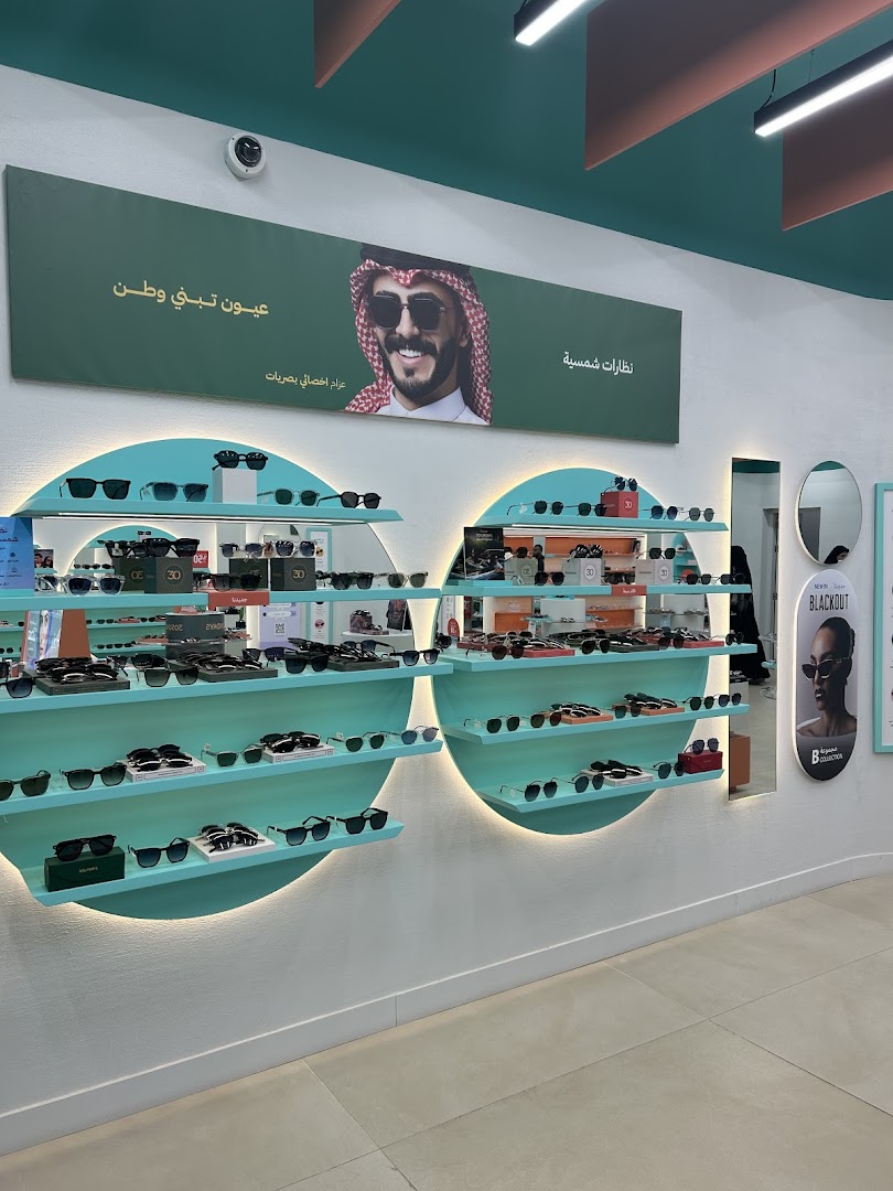 Interior view of an eyeglass shop showcasing a wide selection of sunglasses on display shelves.