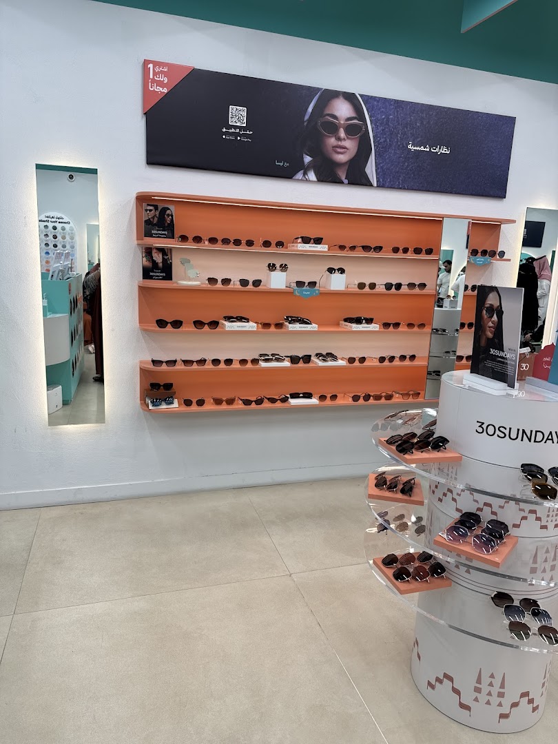 Interior view of an eyewear shop showcasing a wide selection of sunglasses on display shelves and stands.