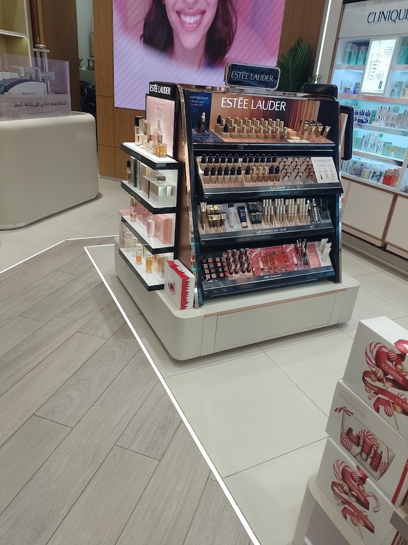 Estee Lauder makeup and skincare products displayed on shelves in a retail store.