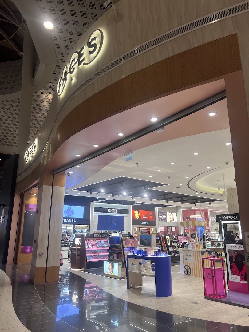 The entrance to FACES, a beauty store, showcasing various cosmetic brands and displays.
