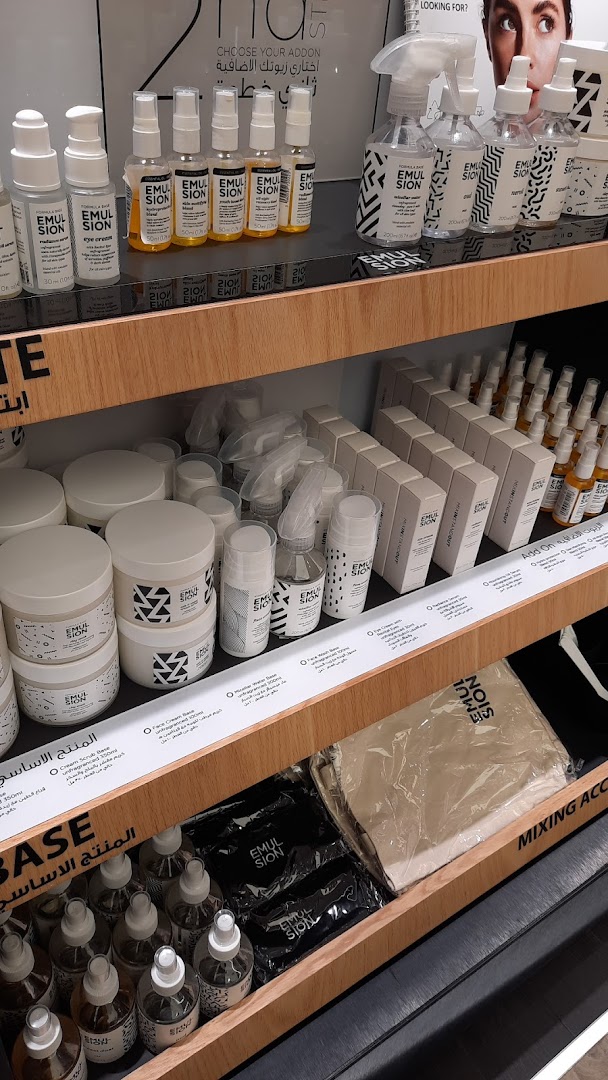 A display of various skincare products, including bottles, jars, and boxed items, on wooden shelves.