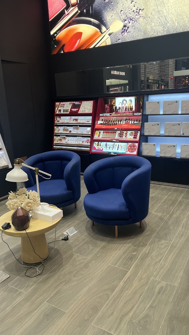 Interior view of a beauty store with makeup displays and seating.
