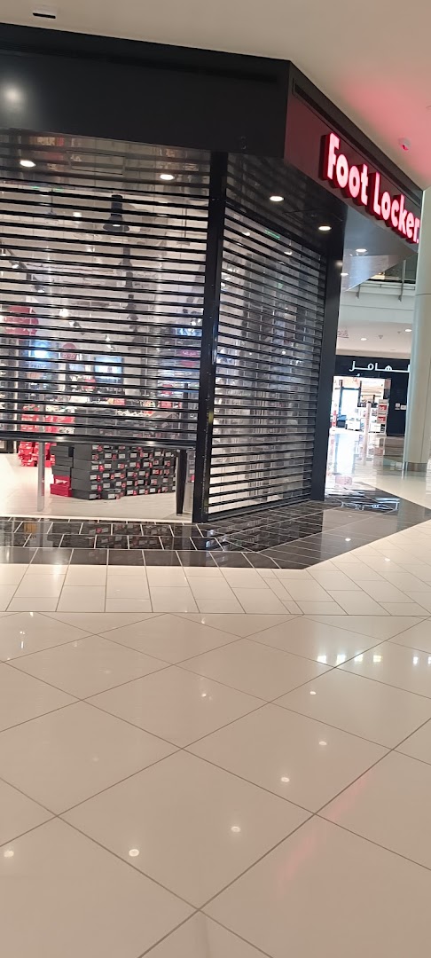 The closed Foot Locker store with its signature red logo and rows of shoe boxes visible inside.