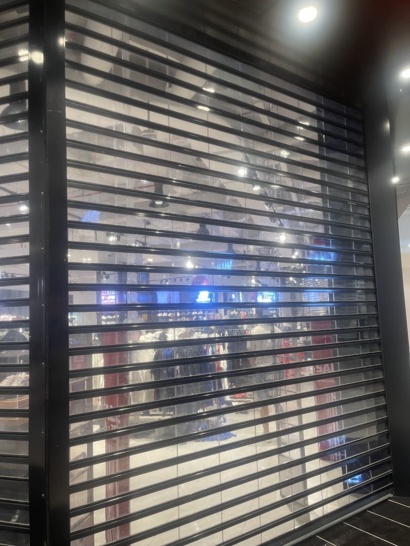 Foot Locker shop with its security shutters down, showing merchandise inside.
