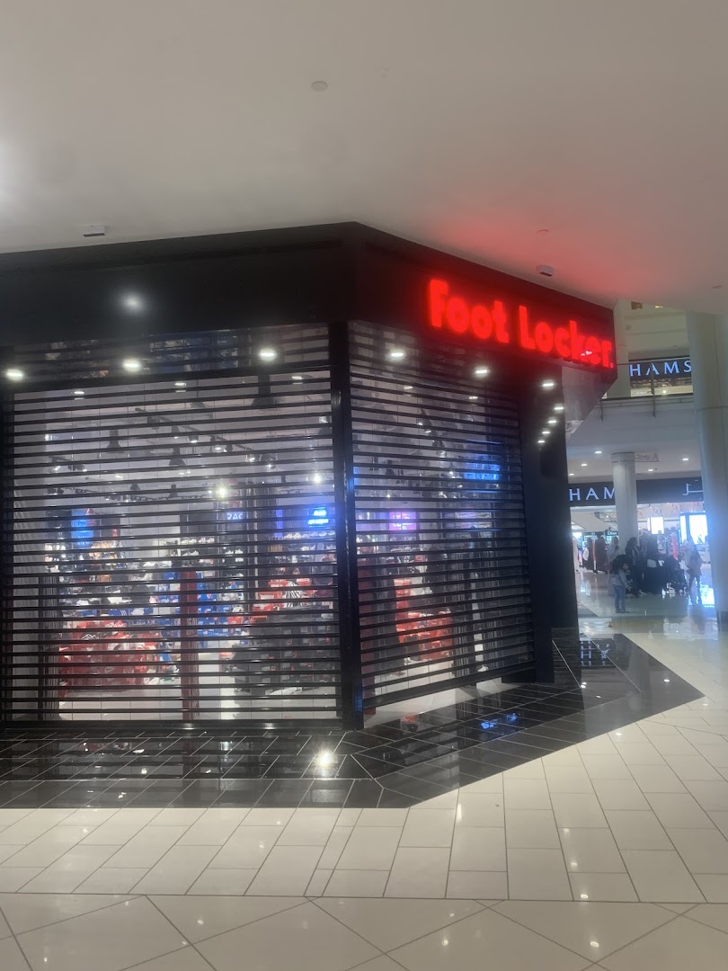 The Foot Locker store with its red neon sign and closed security shutters.