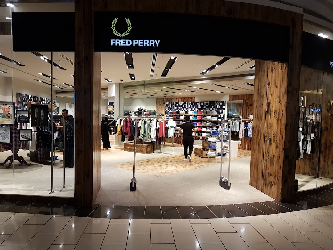 The entrance to a Fred Perry clothing store, showcasing apparel and a modern interior.