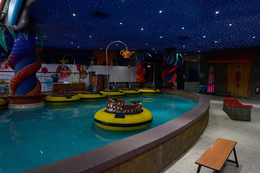 Indoor bumper boat ride with a starry ceiling and colorful decorations.