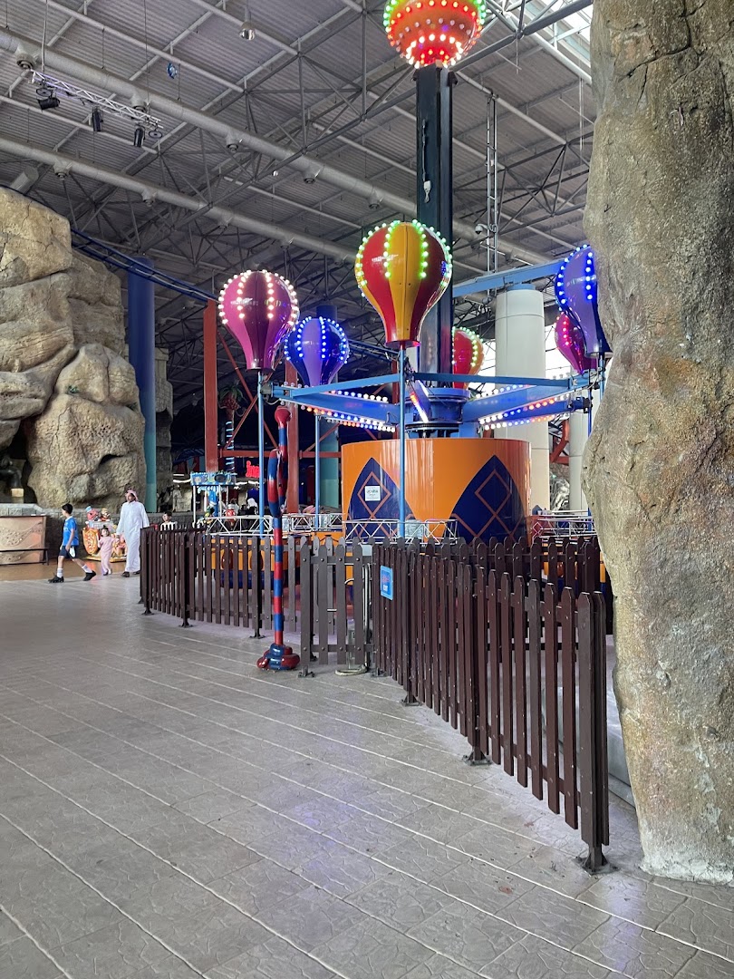 An indoor amusement park ride with colorful hot air balloon-themed gondolas.