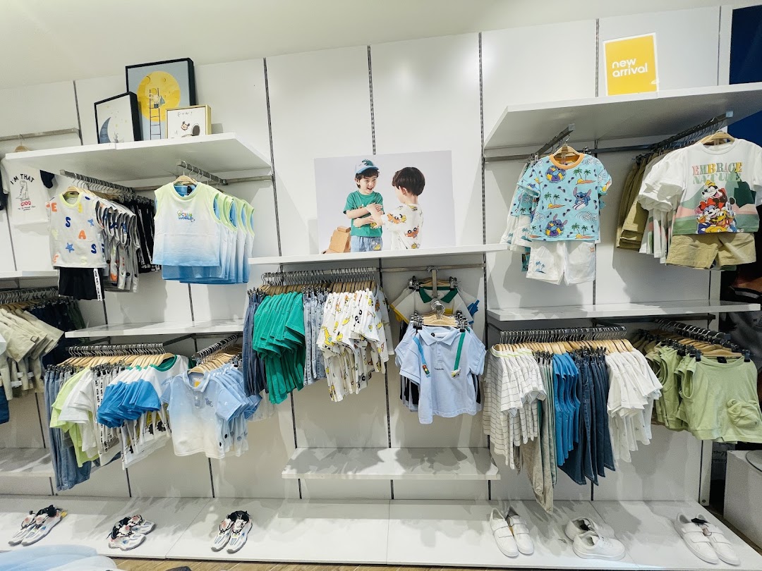 A well-organized display of children's clothing and shoes in a retail store.