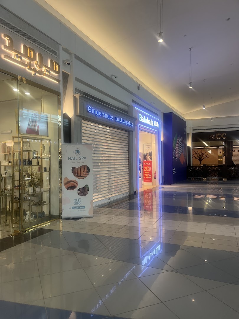 The Gingersnaps store front in a mall, with a closed shutter and a sale poster.